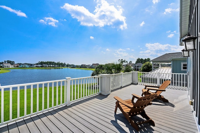 wooden terrace with a yard and a water view