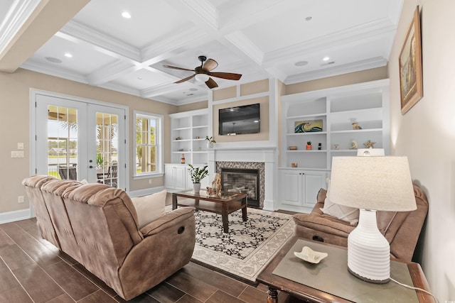 living room featuring french doors, ceiling fan, built in features, a premium fireplace, and beam ceiling