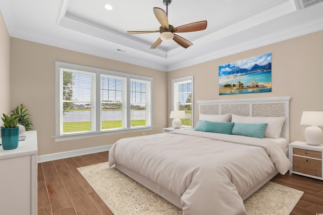 bedroom with a raised ceiling, ceiling fan, and ornamental molding