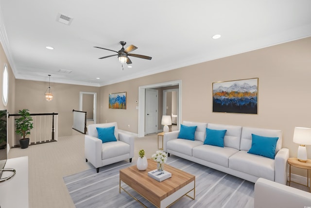 carpeted living room featuring ceiling fan and ornamental molding