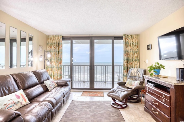 living room with light tile patterned floors, expansive windows, and a textured ceiling