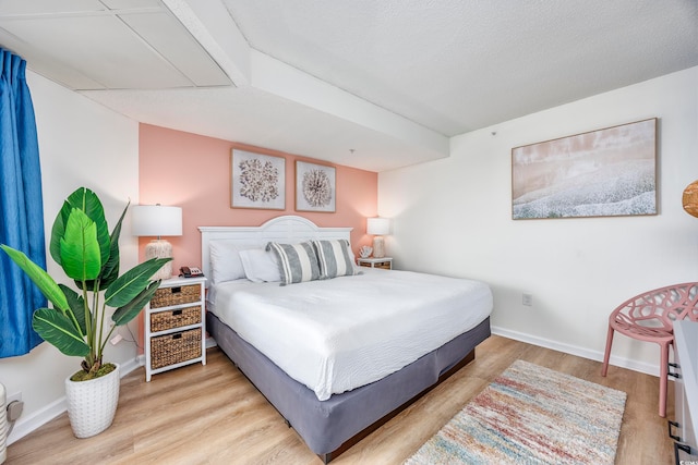 bedroom featuring light wood-type flooring and a textured ceiling