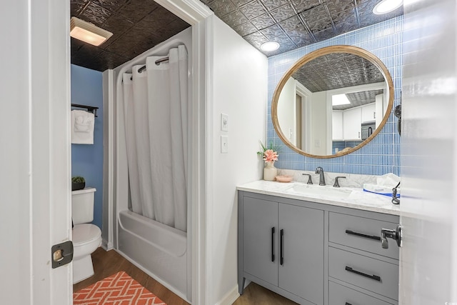 full bathroom featuring vanity, shower / bath combo, wood-type flooring, tile walls, and toilet