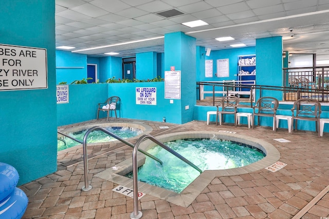 view of swimming pool featuring an indoor hot tub