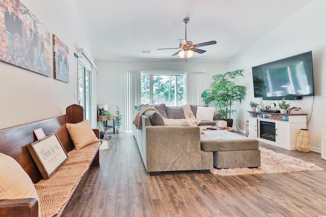 living room featuring ceiling fan, lofted ceiling, and wood-type flooring