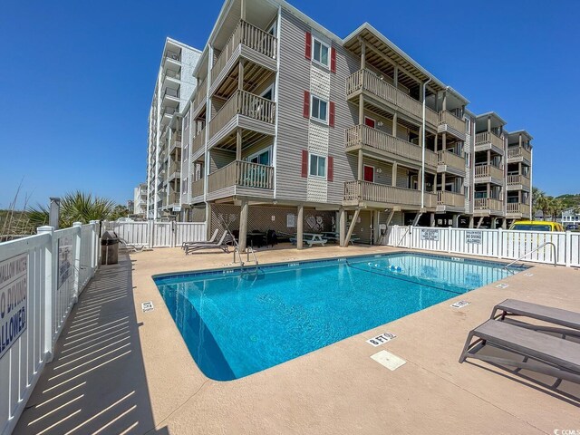 pool featuring a patio area and fence