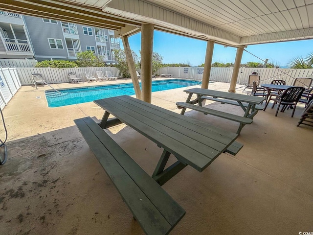 community pool featuring a patio area and a fenced backyard