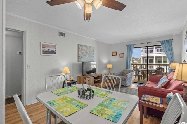 4305 S Ocean Blvd Unit 106, North Myrtle Beach, SC 29582 - dining space with light wood finished floors, ceiling fan, ornamental molding, a textured ceiling, and a textured wall