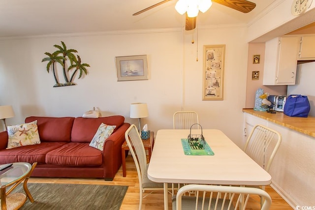 dining area featuring ceiling fan, light hardwood / wood-style flooring, and ornamental molding