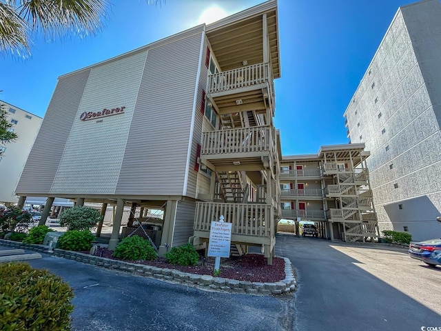 view of property featuring stairs and uncovered parking