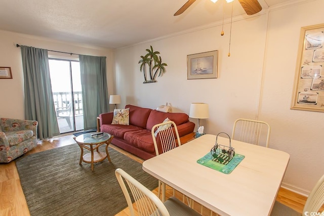 interior space featuring baseboards, a ceiling fan, wood finished floors, and crown molding