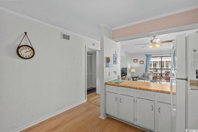 4305 S Ocean Blvd Unit 106, North Myrtle Beach, SC 29582 - kitchen with freestanding refrigerator, a textured wall, light wood-type flooring, ornamental molding, and ceiling fan
