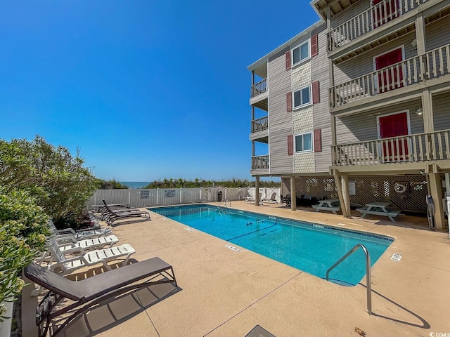 pool with a patio and fence