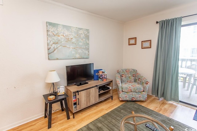 sitting room with wood finished floors, baseboards, and ornamental molding