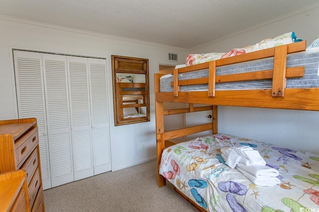 bedroom featuring a closet, carpet flooring, visible vents, and ornamental molding