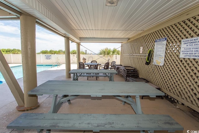 view of patio featuring outdoor dining space, a fenced backyard, and a community pool