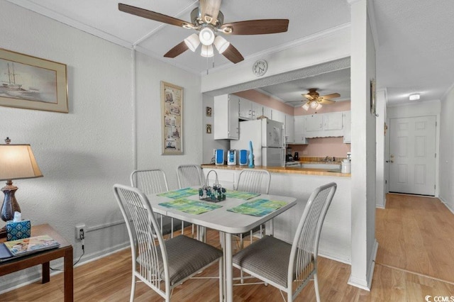 4305 S Ocean Blvd Unit 106, North Myrtle Beach, SC 29582 - dining area featuring a ceiling fan, crown molding, and light wood-style flooring
