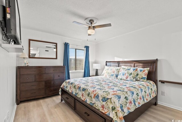 6001 N Ocean Blvd Unit 242, North Myrtle Beach, SC 29582 - bedroom featuring ceiling fan, a textured ceiling, and light wood-type flooring