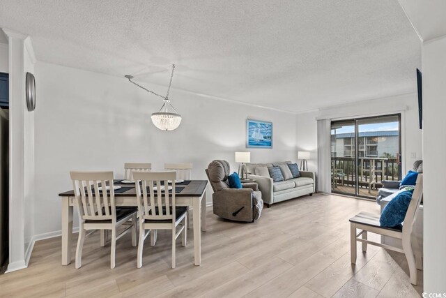 6001 N Ocean Blvd Unit 242, North Myrtle Beach, SC 29582 - living room with light wood-type flooring, a textured ceiling, and a chandelier
