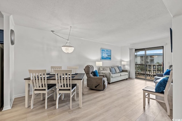 6001 N Ocean Blvd Unit 242, North Myrtle Beach, SC 29582 - living area featuring a textured ceiling, light wood-style floors, and a chandelier