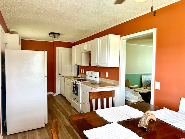 kitchen featuring white cabinetry, ornamental molding, a textured ceiling, white appliances, and dark wood-type flooring