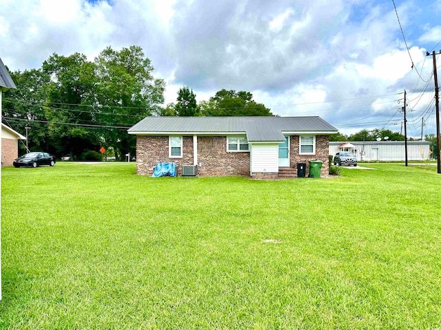 view of front of property with a front lawn and central AC unit