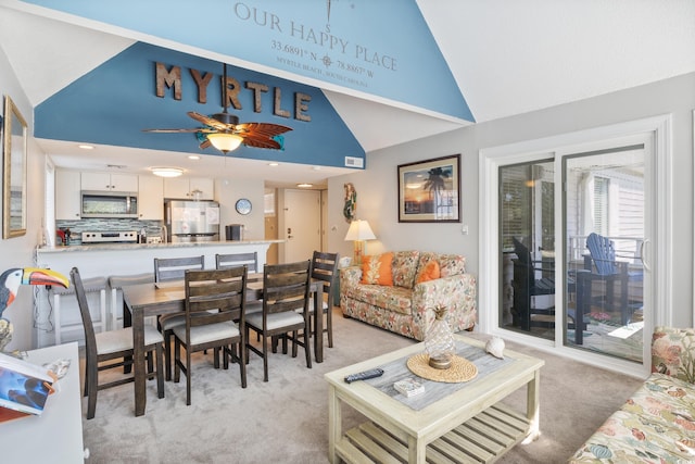 dining room with high vaulted ceiling, ceiling fan, and light colored carpet