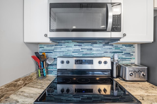 kitchen with appliances with stainless steel finishes, decorative backsplash, and white cabinetry