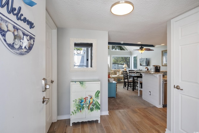 entrance foyer featuring light hardwood / wood-style floors, ceiling fan, and a textured ceiling