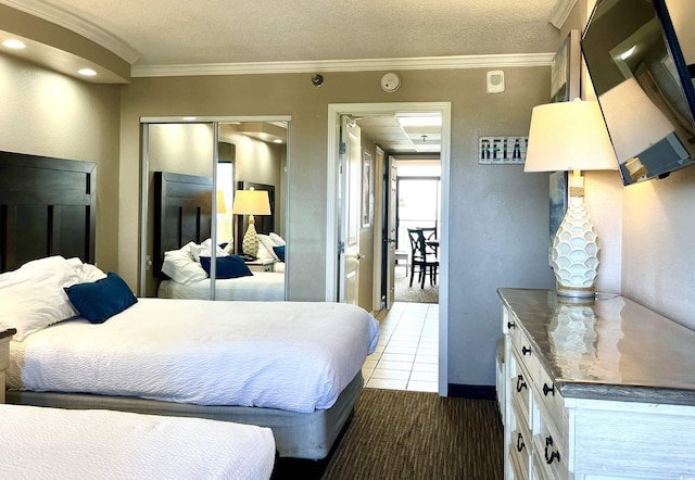 bedroom with ornamental molding, tile patterned flooring, a closet, and a textured ceiling