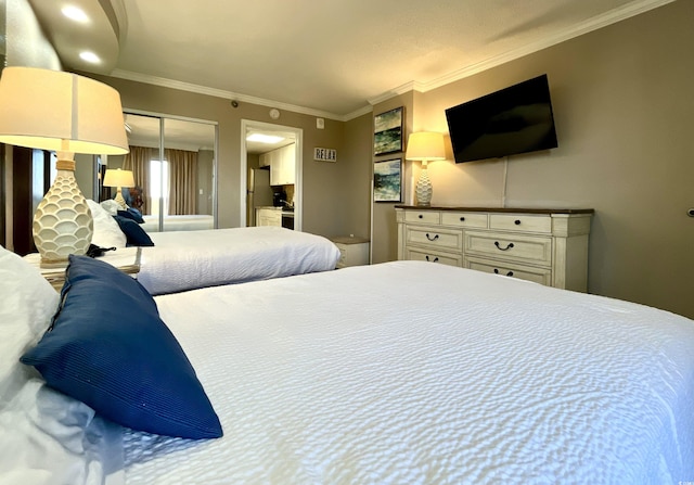 bedroom with stainless steel fridge, ornamental molding, and a closet