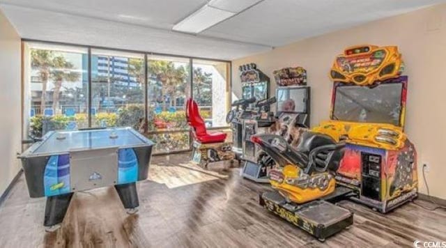 recreation room featuring a wall of windows and hardwood / wood-style floors