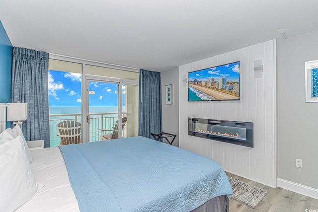 bedroom featuring access to exterior and light hardwood / wood-style flooring