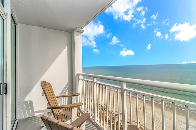 balcony featuring a water view and a beach view