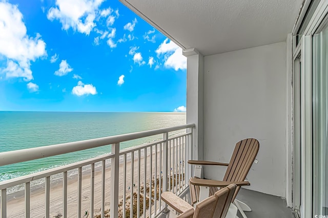 balcony featuring a beach view and a water view