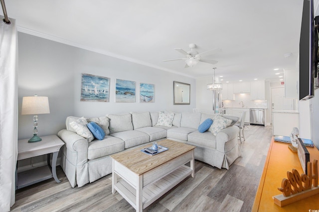 living room featuring ceiling fan, light wood-style flooring, and crown molding