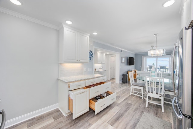 kitchen featuring ornamental molding, freestanding refrigerator, white cabinetry, and decorative backsplash