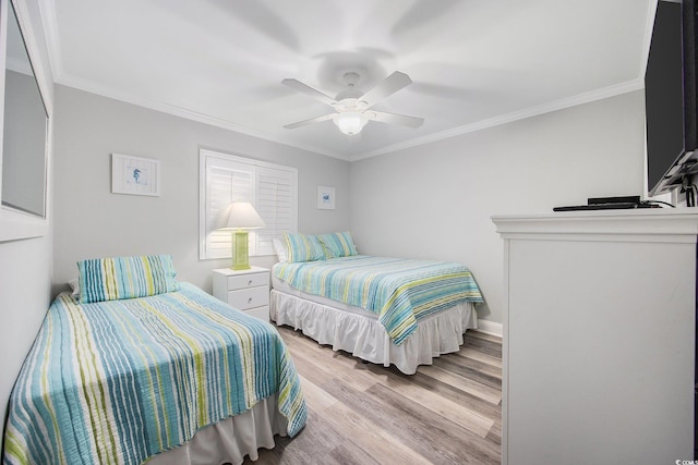 bedroom featuring light wood-style floors, crown molding, baseboards, and a ceiling fan