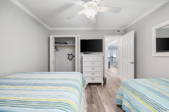 bedroom featuring ornamental molding, wood finished floors, visible vents, and a ceiling fan