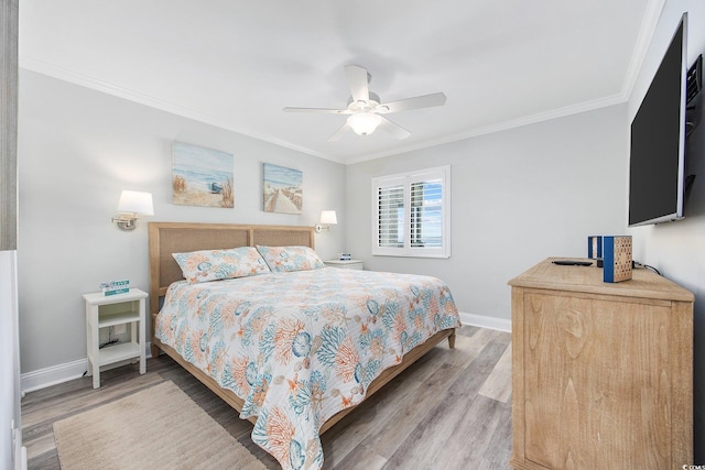 bedroom with crown molding, ceiling fan, light wood-style floors, and baseboards