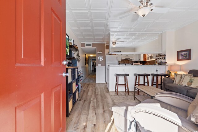 living room with ceiling fan and light hardwood / wood-style floors