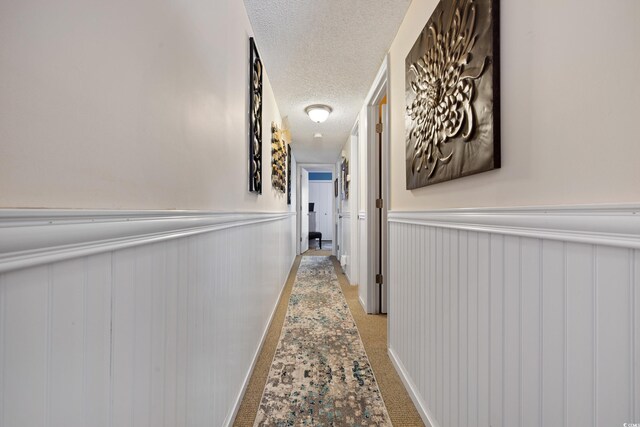 corridor featuring carpet floors and a textured ceiling