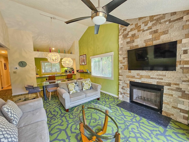 living room with a textured ceiling, vaulted ceiling, carpet flooring, and a stone fireplace