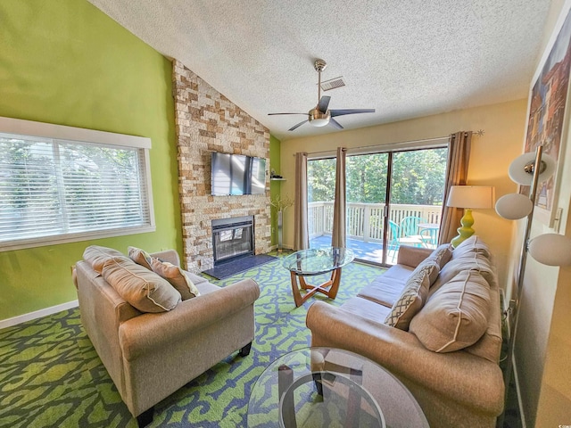 living room with ceiling fan, a fireplace, a textured ceiling, and lofted ceiling