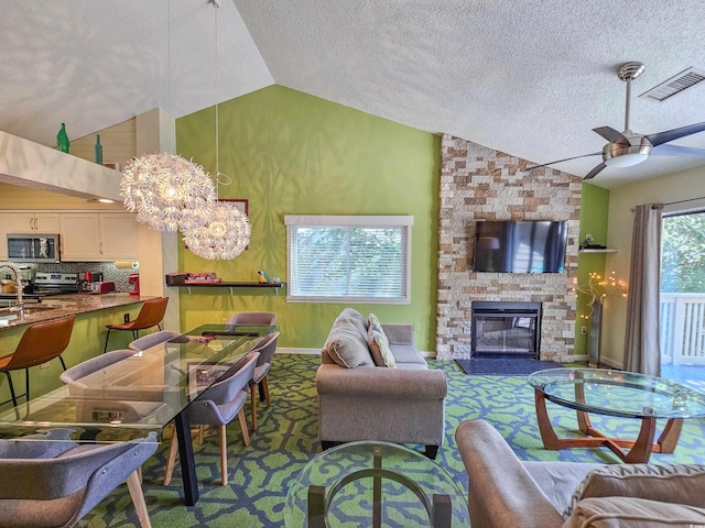 living room with a textured ceiling, lofted ceiling, and a stone fireplace