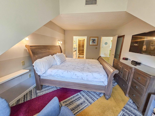 bedroom with carpet floors, vaulted ceiling, and connected bathroom