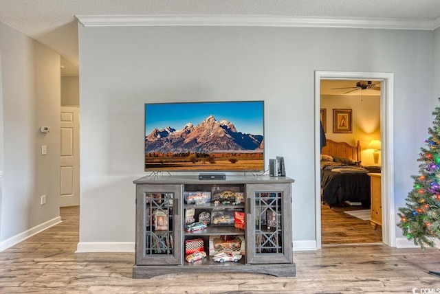 interior space with a textured ceiling, hardwood / wood-style flooring, bar area, and crown molding