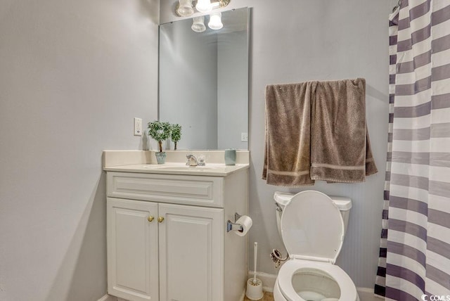 bathroom with curtained shower, vanity, and toilet