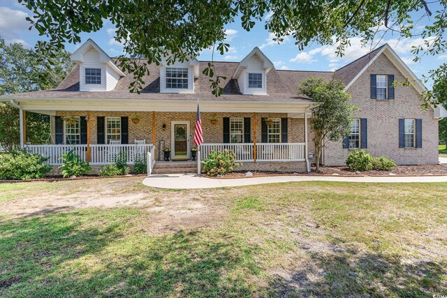 cape cod home with a front lawn and a porch