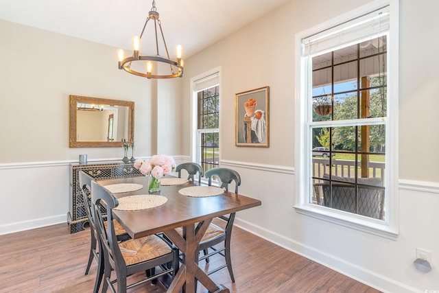 dining area featuring baseboards, dark wood-type flooring, and an inviting chandelier